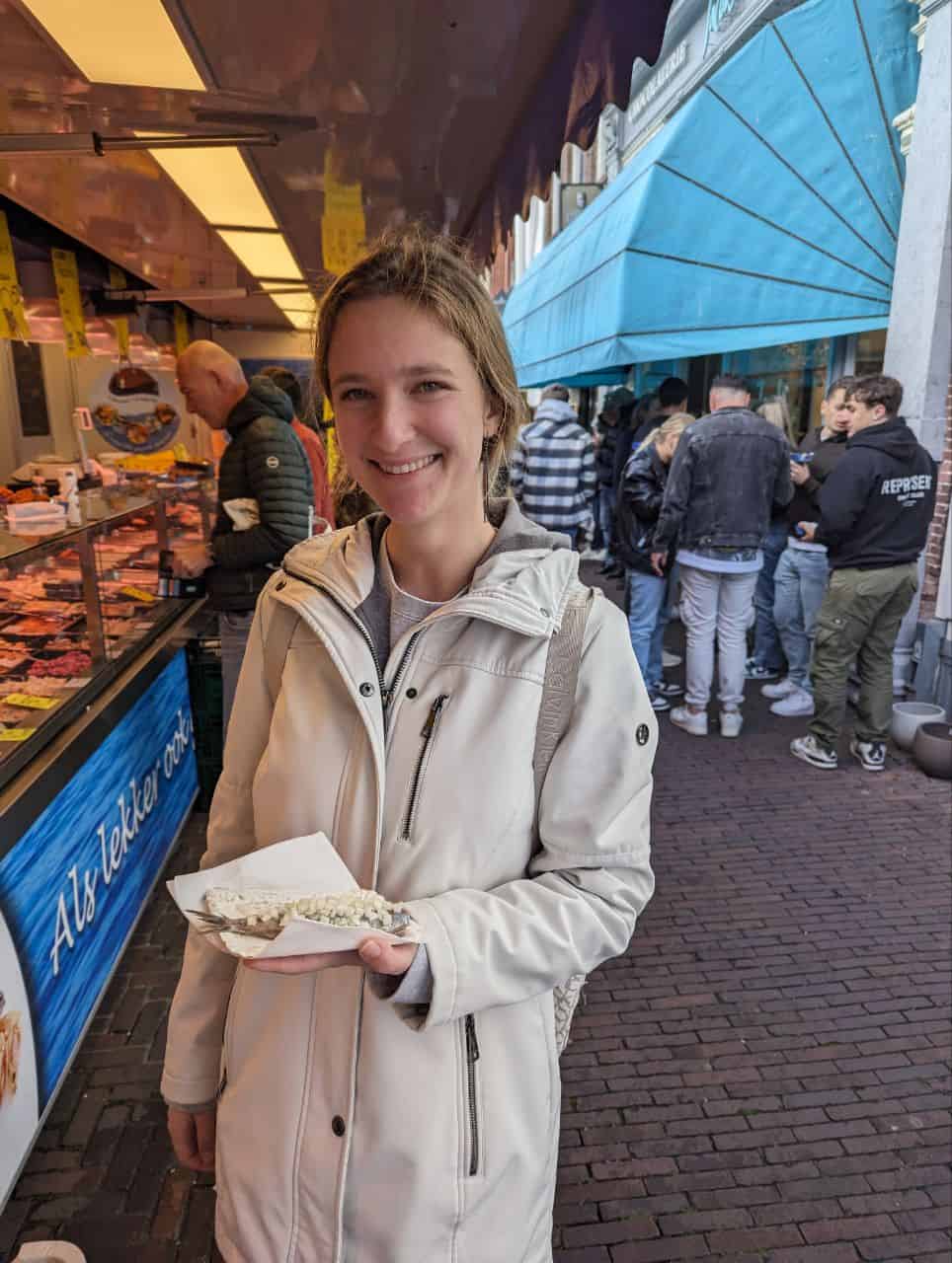 Best things to do in Leiden Netherlands - Marina Krivonossova - Marina with herring at a fish stall at the local Saturday market